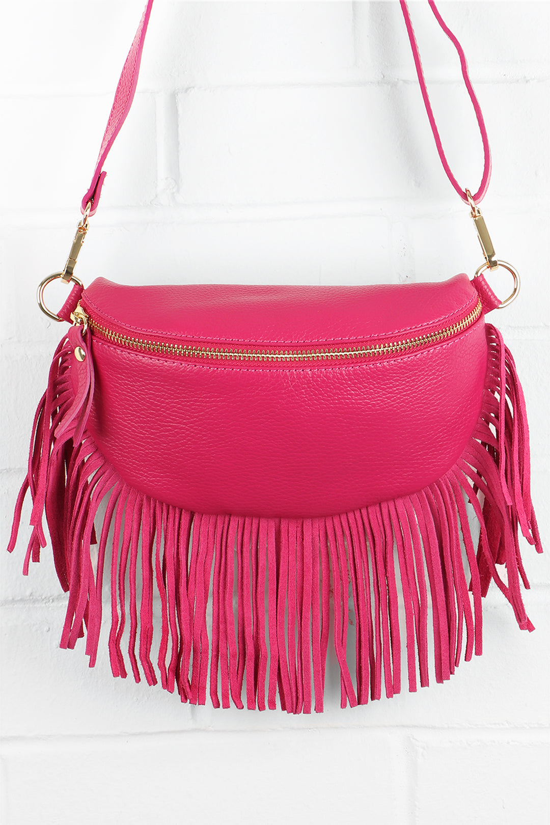 fuchsia pink leather halfmoon bag with fringed trim and zip closure
