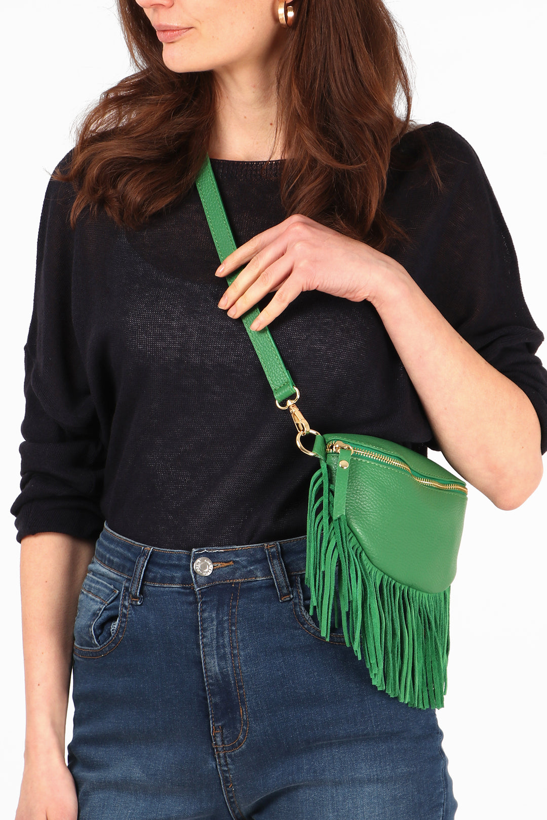 close up of the tassel trim edge and zip closure fastening on this green leather bag