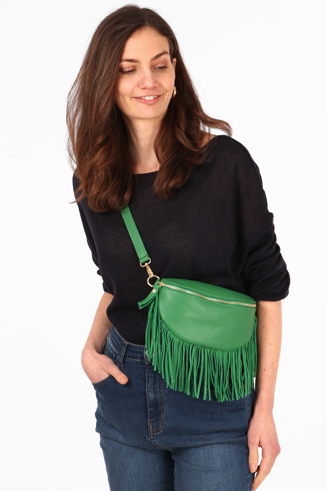model wearing a bright green half moon cross body leather bag with a fringed trim and gold zip closure