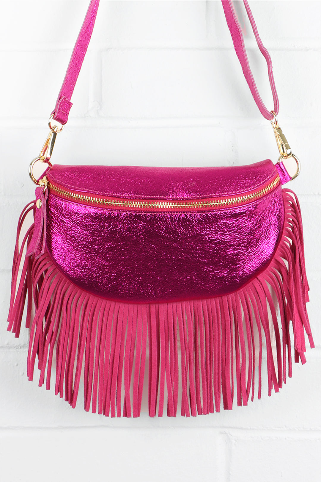 metallic raspberry pink leather halfmoon bag with fringed trim and zip closure