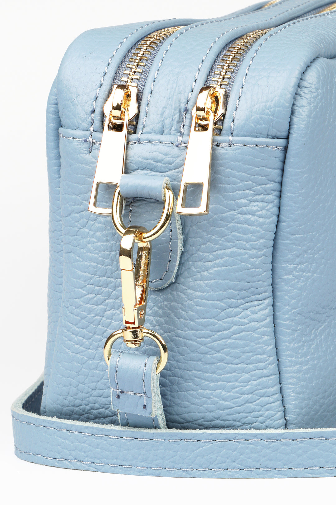 close up of the light blue leather and gold hardware on the cross body bag