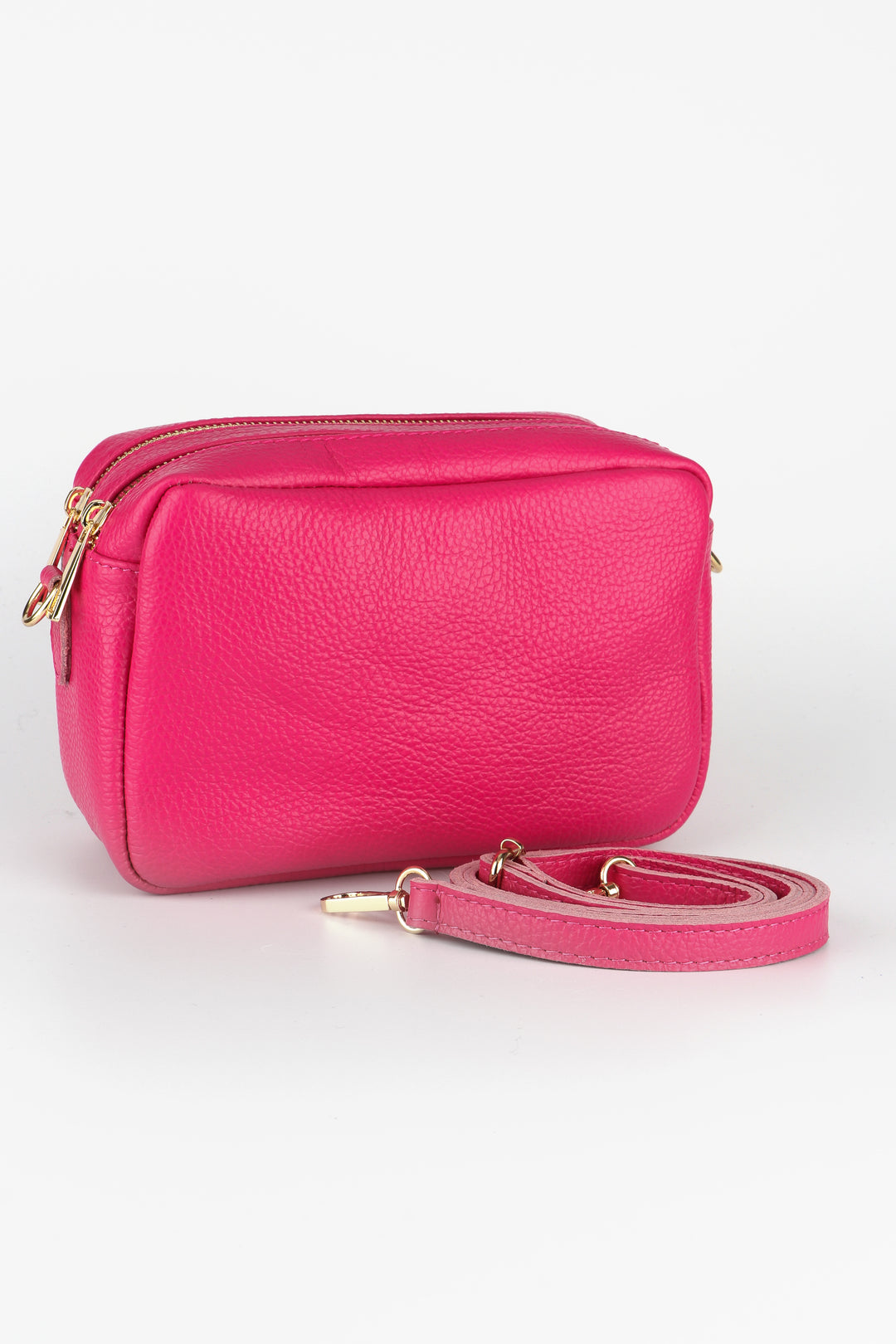 raspberry pink leather crossbody bag with two zip closing compartments and a detachable bag strap