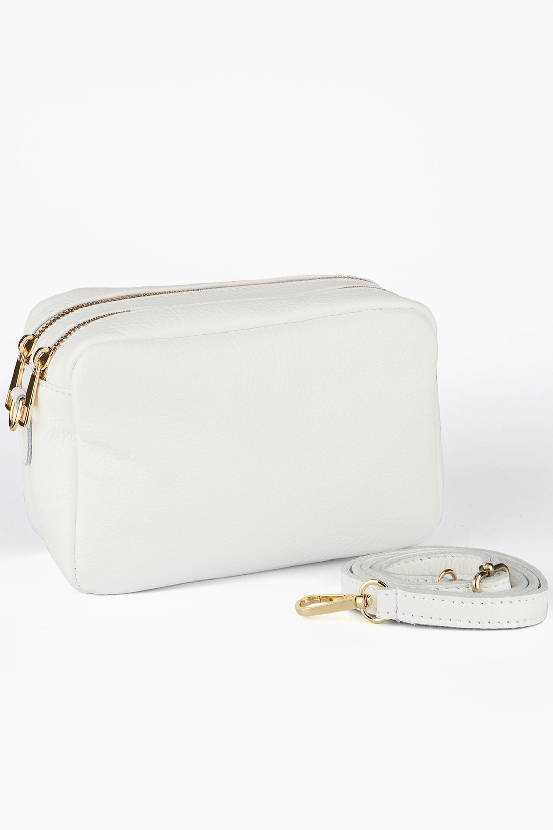 white leather cross body camera bag with two zip closing compartments and a detachable matching bag strap