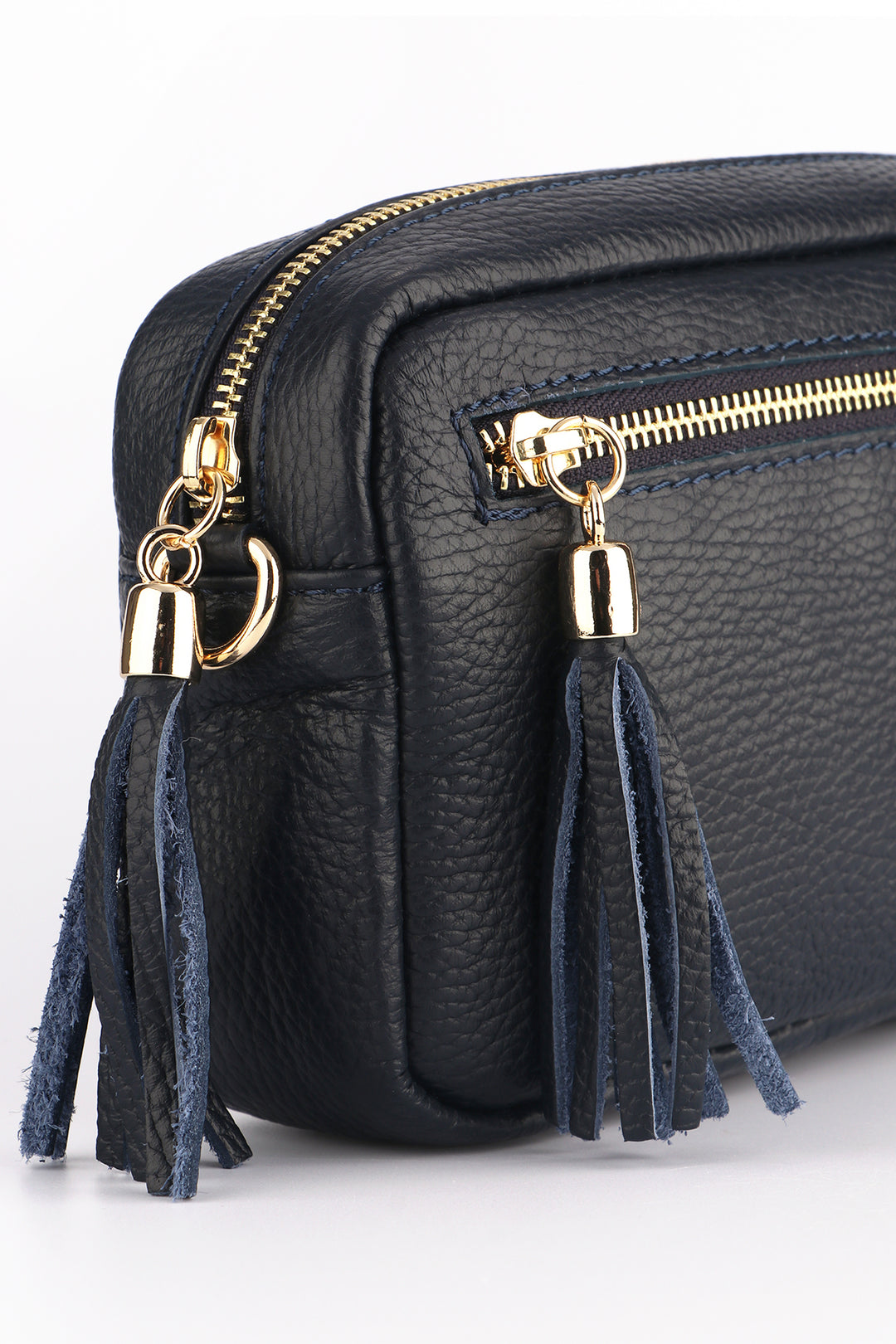 close up of the navy blue leather camera bag with tassles and gold zip fasternings
