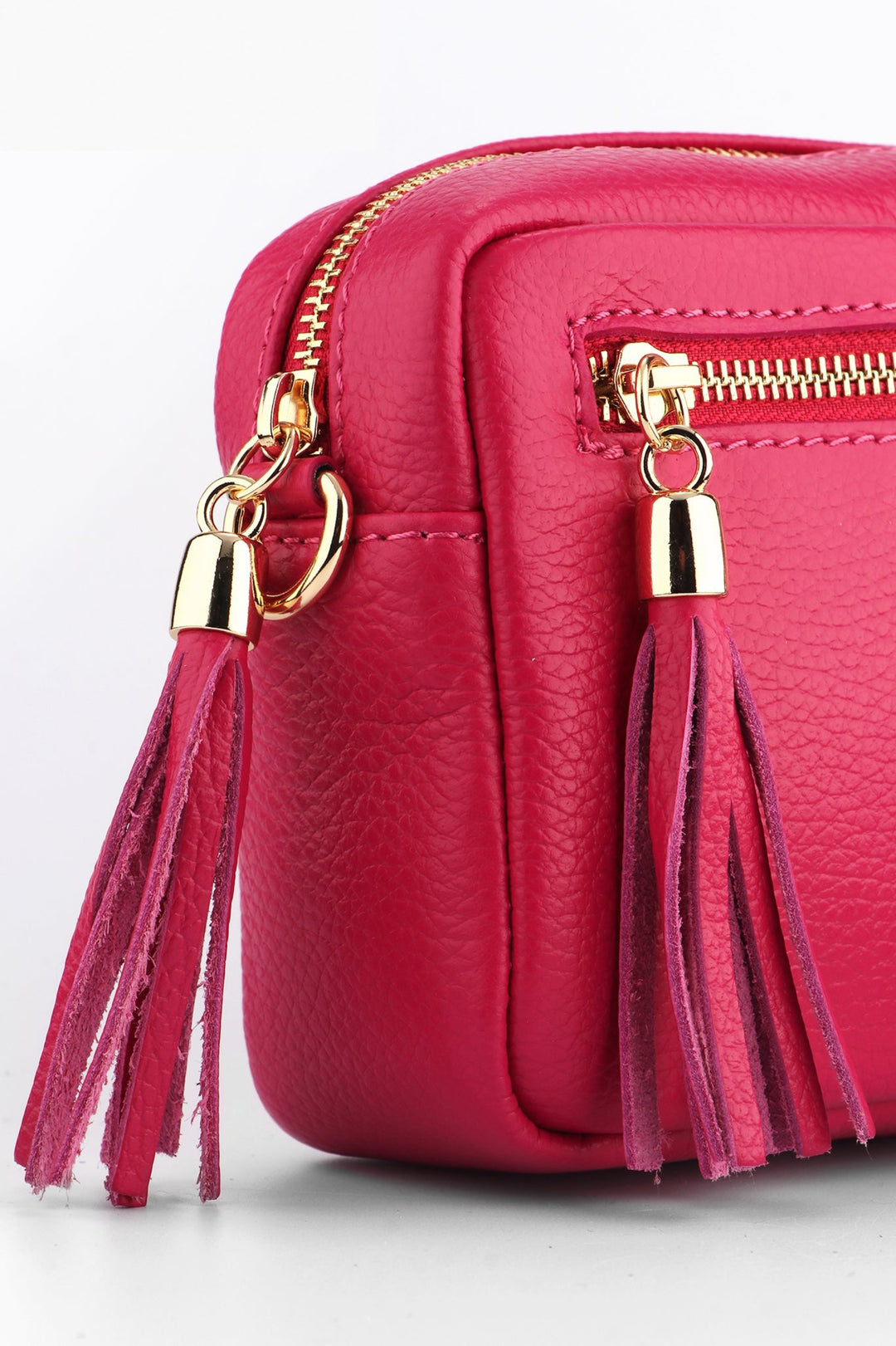 close up of the two tassel trims on the zip closure of the small crossbody bag