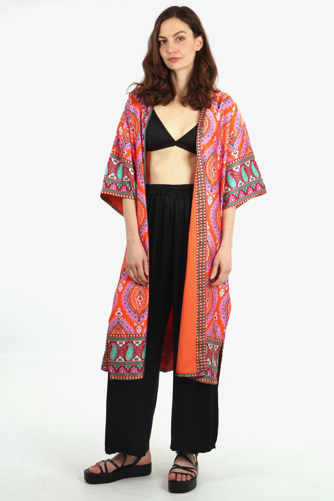model wearing an orange madala print mid length open front kimono jacket with 3/4 sleeves
