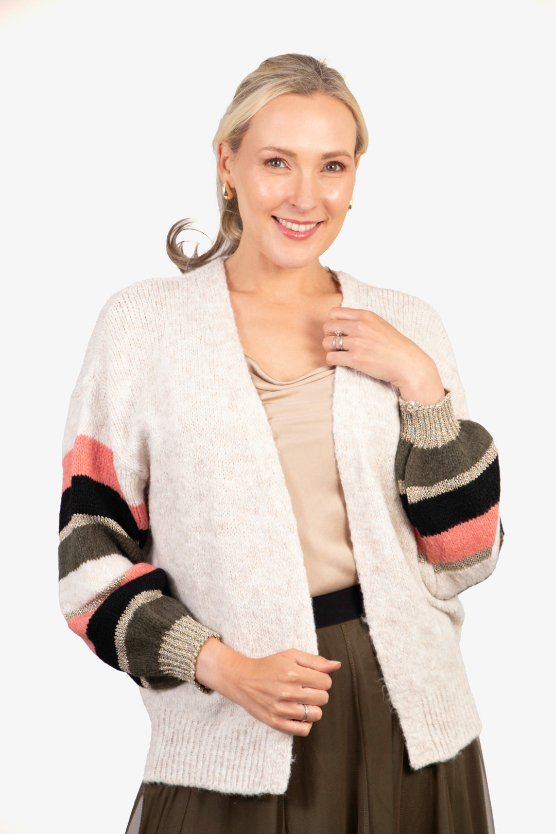 model wearing an open front cream cardigan with striped sleeves in khaki, pink, and gold glitter