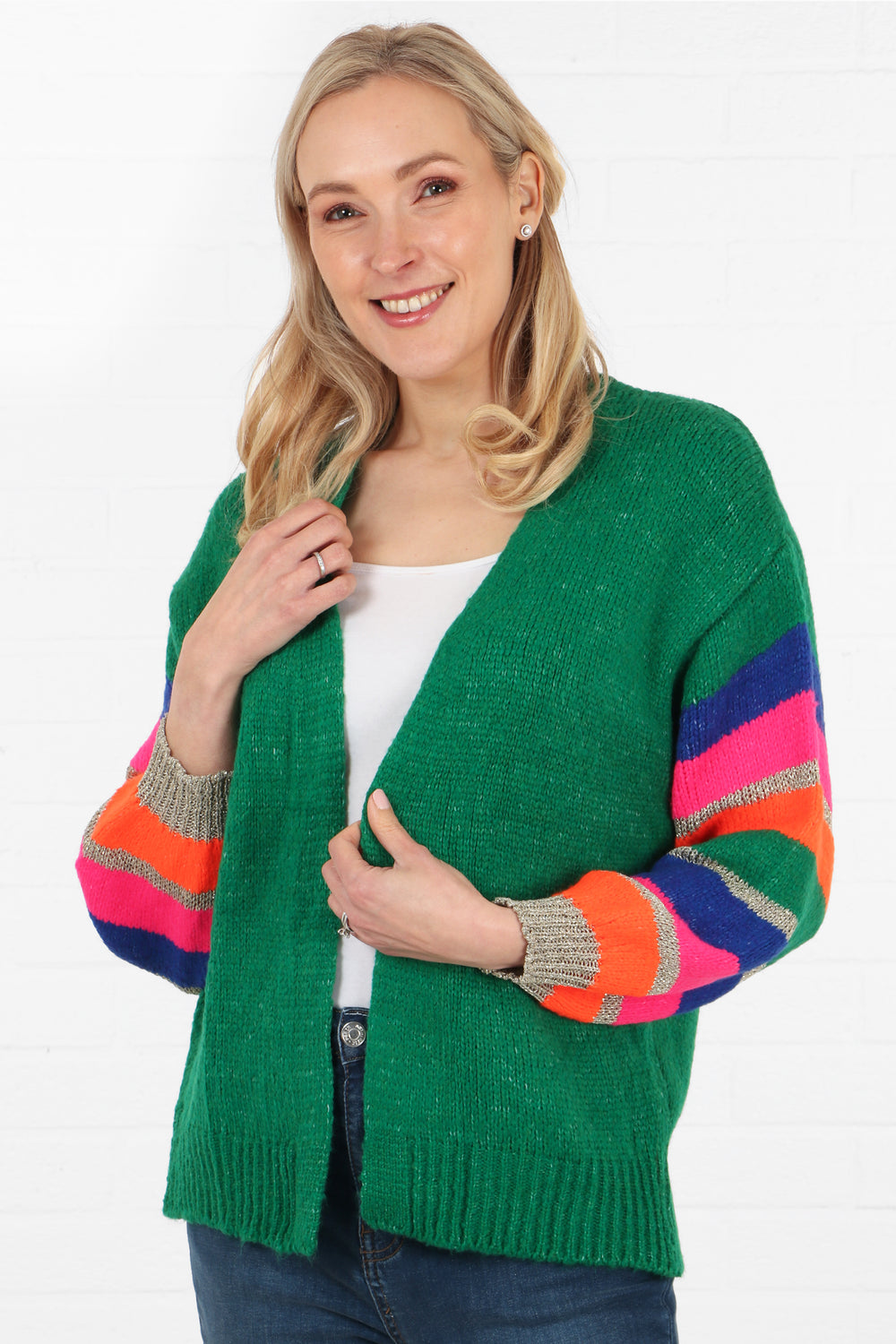 model wearing a green open front knit cardigan with a multicoloured stripe sleeve