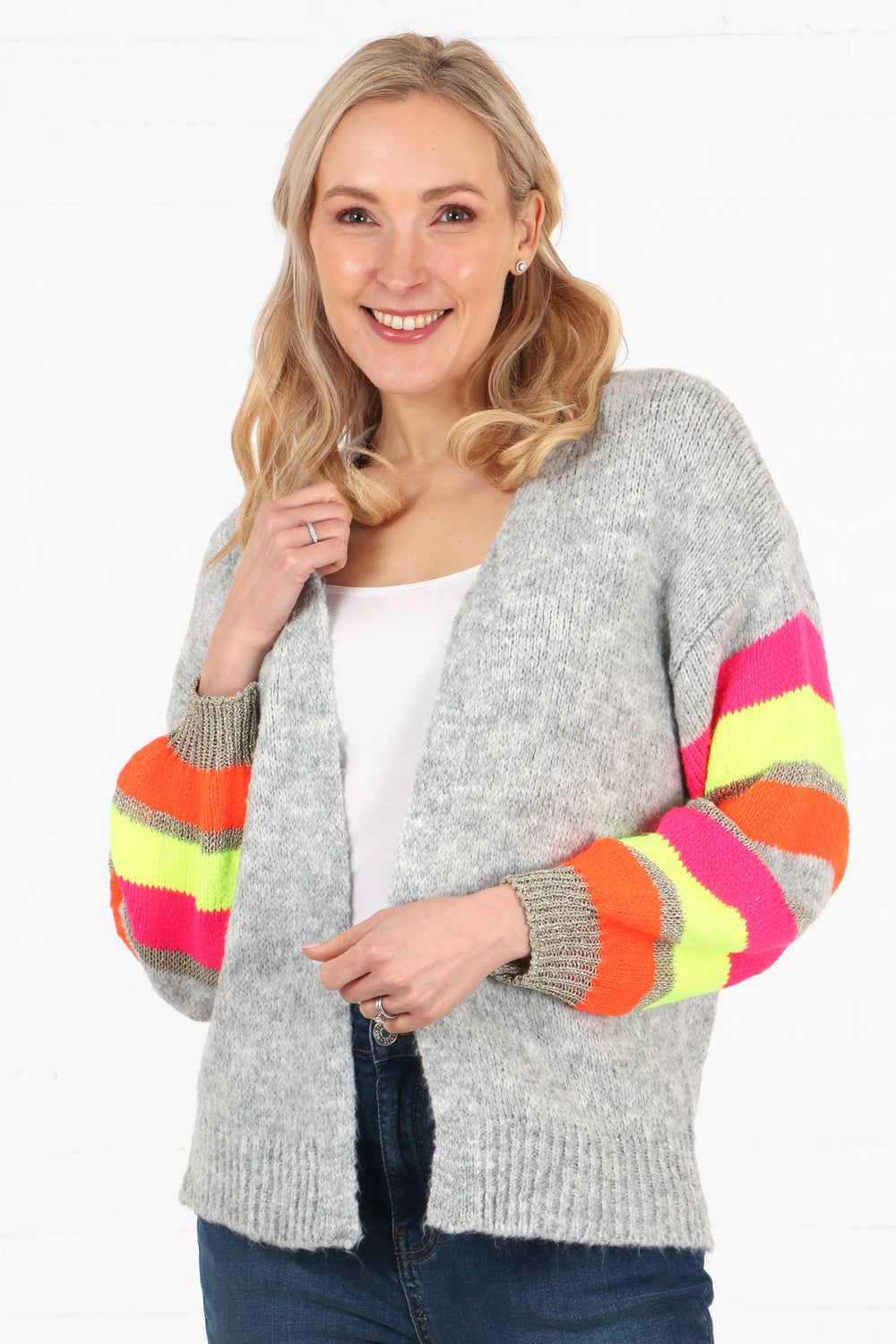 model wearing a short knit cardigan in light grey with multicoloured striped sleeves