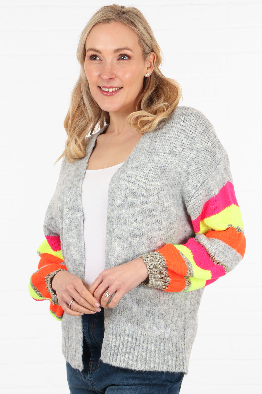 model wearing a light grey open cardigan with colour striped sleeves