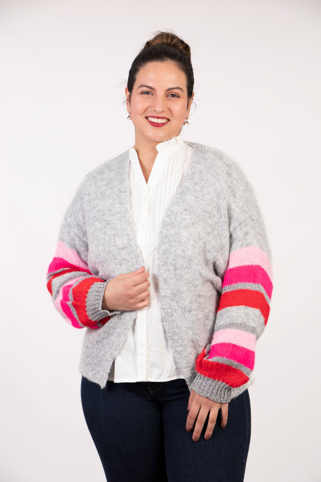 model wearing a light grey long sleeve cardigan, the sleeves are red, pink and silver glitter striped