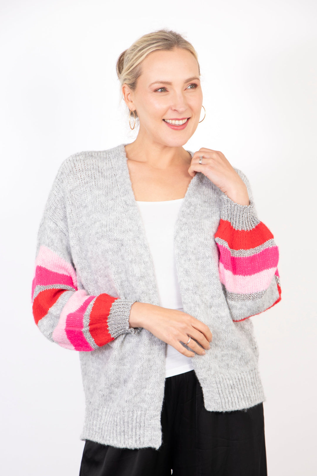 model wearing a light grey open front cardigan with pink and silver striped sleeves