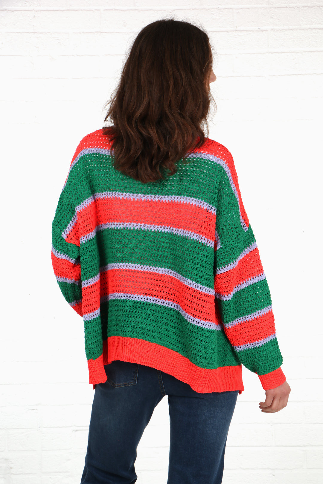 model showing the back of the green and orange striped cardigan showing an all over striped pattern
