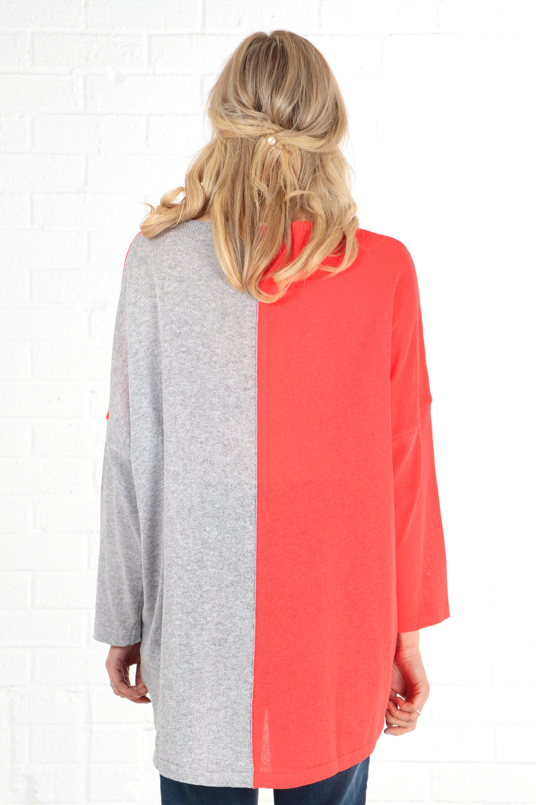 model showing the back of the jumper and its two tone grey and coral pink design