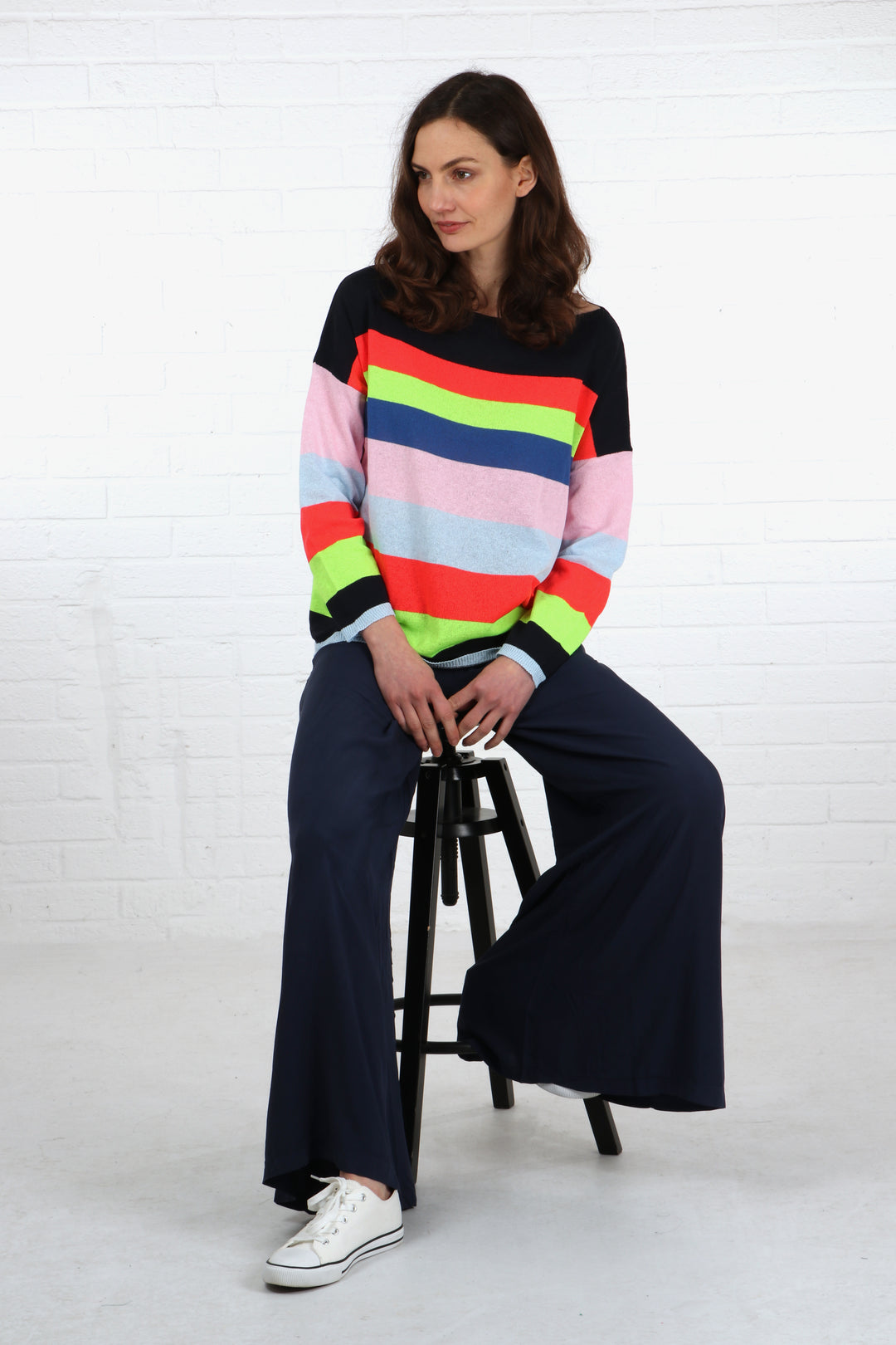 model seated on a stool wearing a pair of plain navy blue palazzo pants