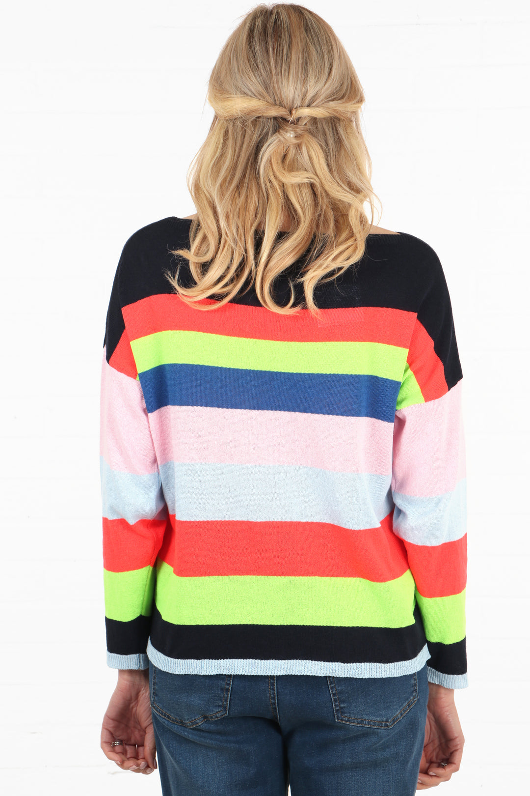model showing the back of the stiped jumper, the stipes are navy blue, orange, neon yellow, blue, white, black and grey
