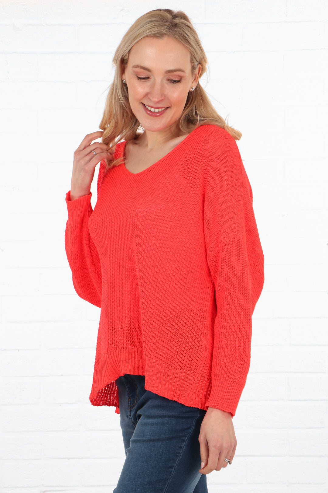 model wearing a long sleeve knitted cotton jumper in coral pink