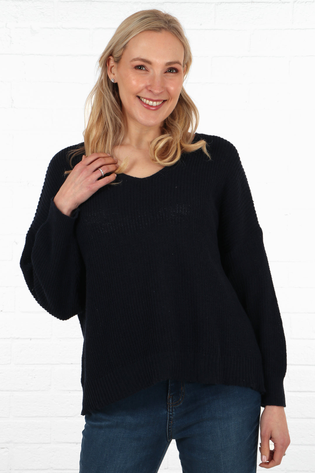 model wearing a fine knitted cotton jumper in navy blue, jumper had long sleeves and a v-neck