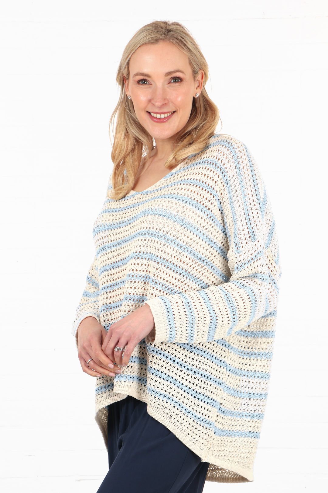 model wearing a lightweight open summer knit cotton jumper with an all over blue and cream stripe pattern
