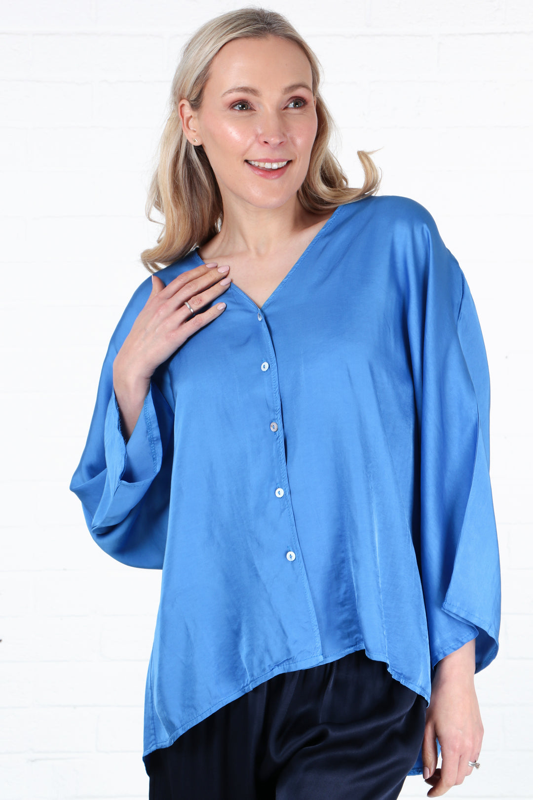 model wearing a faux silk green button down v neck blouse in blue