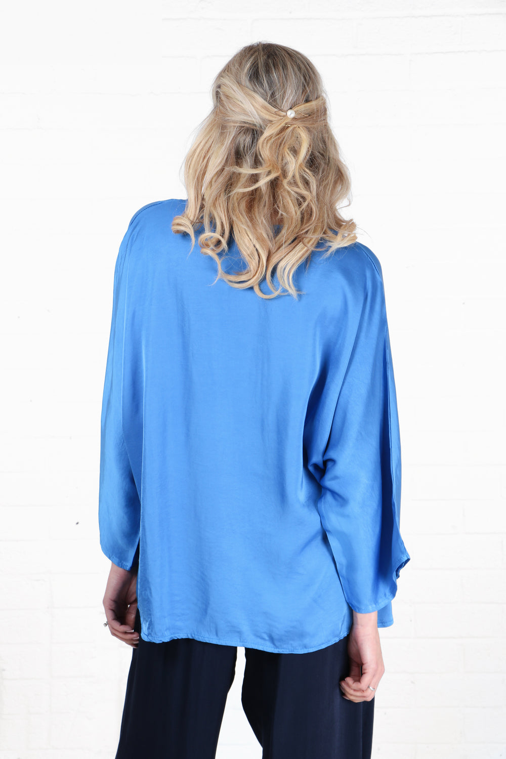 model showing the back of the shirt, showing an all over solid blue pattern