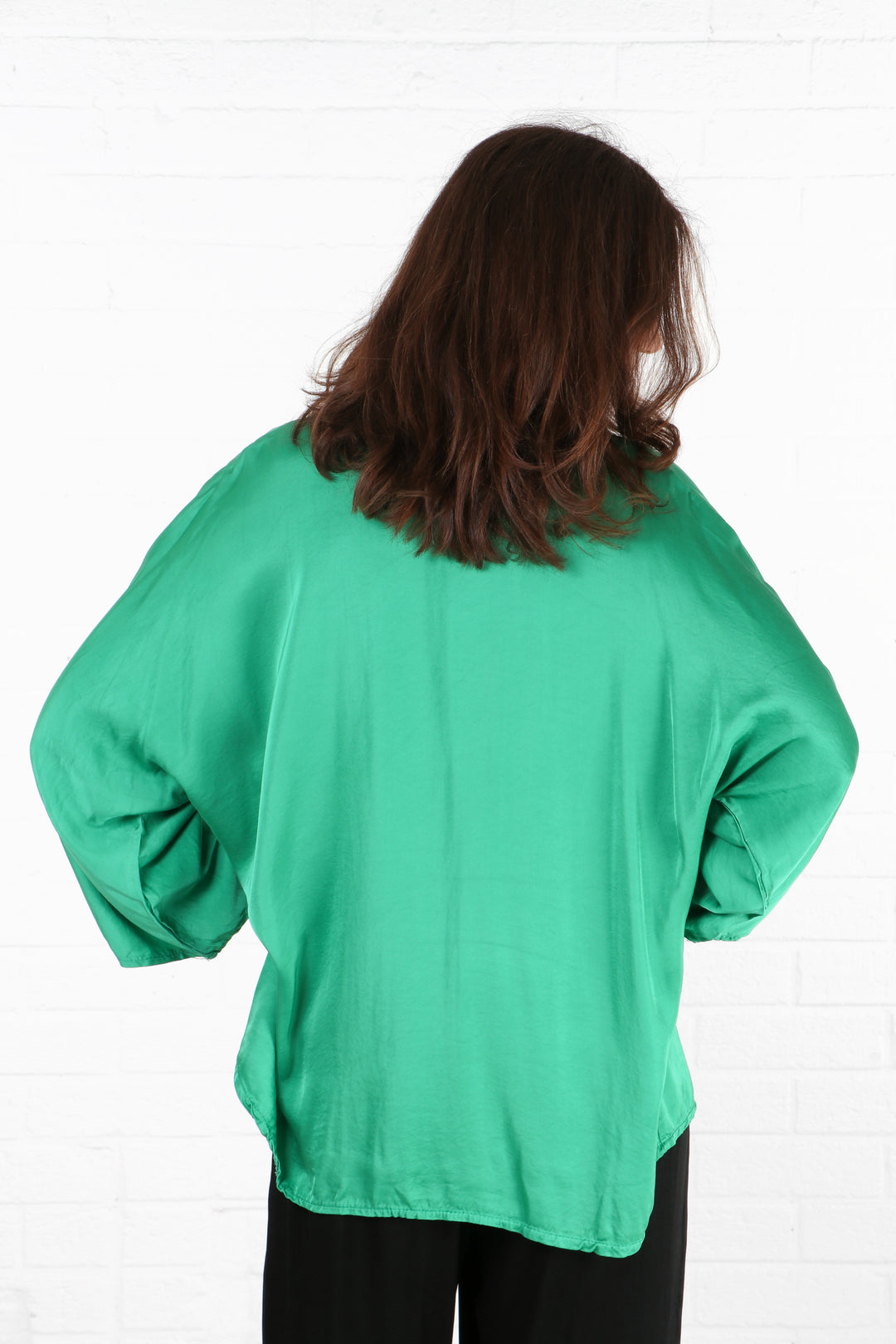 model showing the back of the green shirt, showing an all over solid green pattern