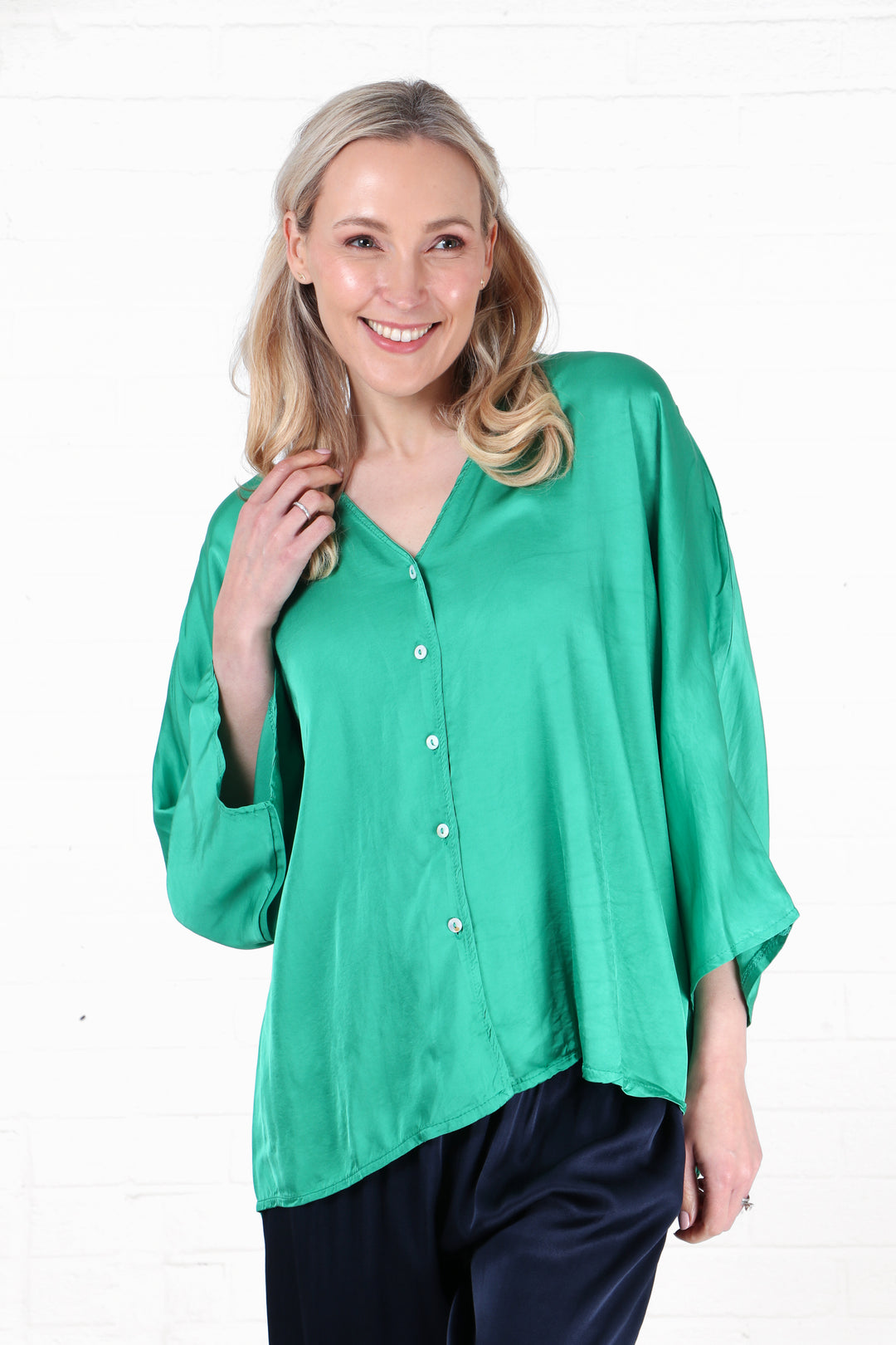 model wearing a faux silk green button down v neck blouse in green