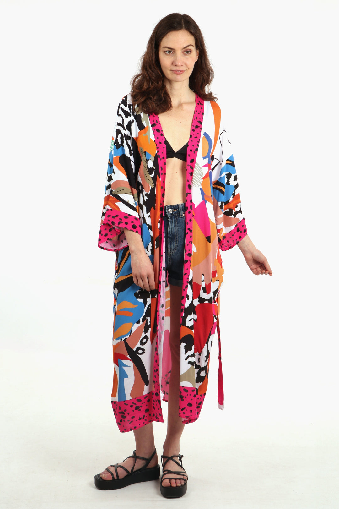 model wearing a colourful pink, white and blue  jungle print pattern long kimono robe. the kimono has 3/4 sleeves and a waist belt tie.