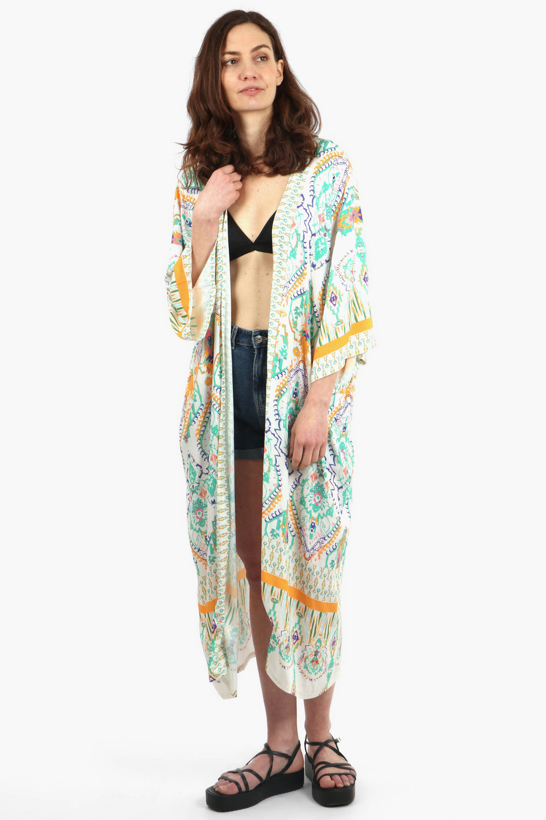 model wearing a cream and green mandala print long kimono robe with 3/4 sleeves, the kimono also features contrasting orange borders on the sleeves and hem 