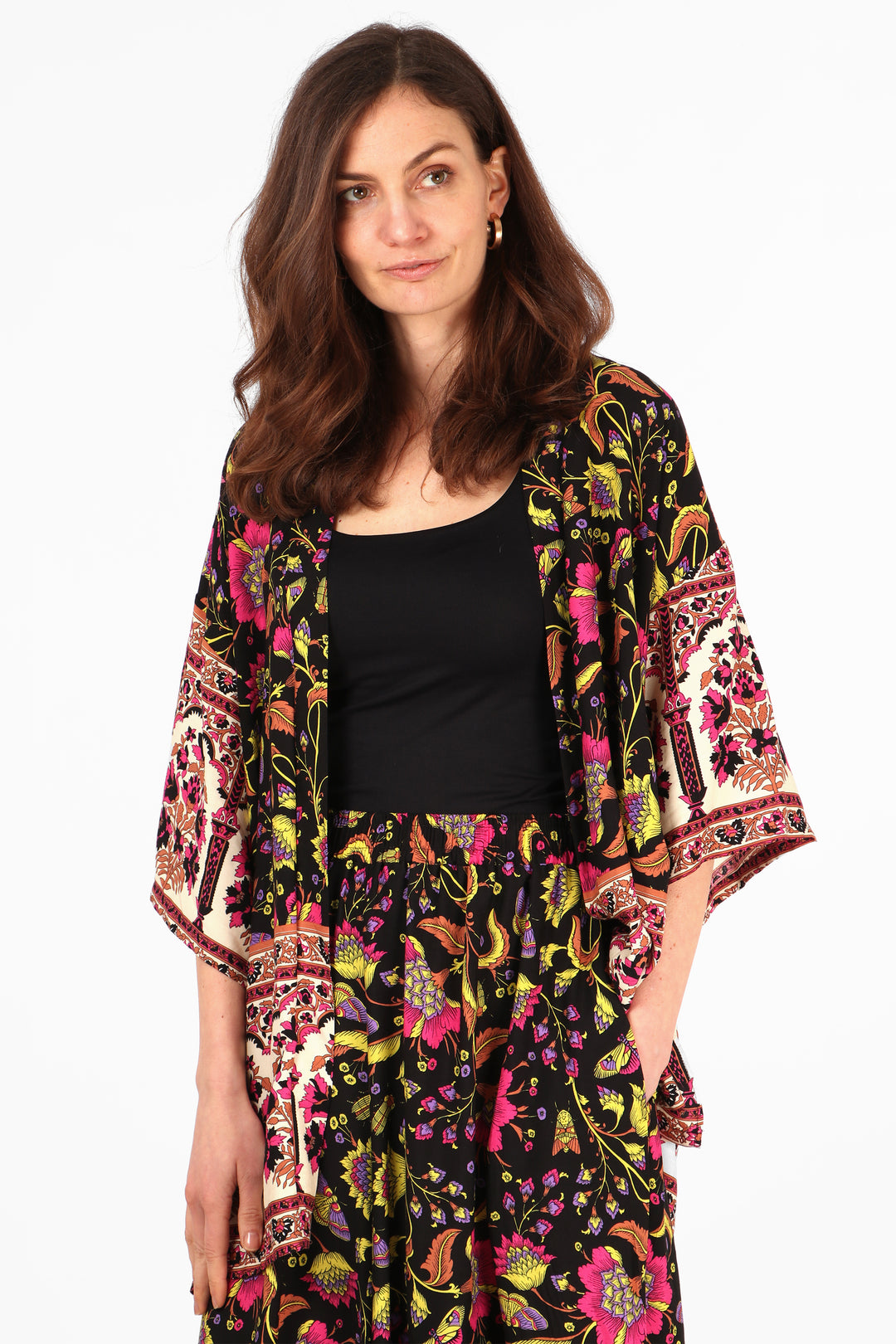 model wearing a black, pink and yellow floral and butterfly pattern short kimono with 3/4 sleeves