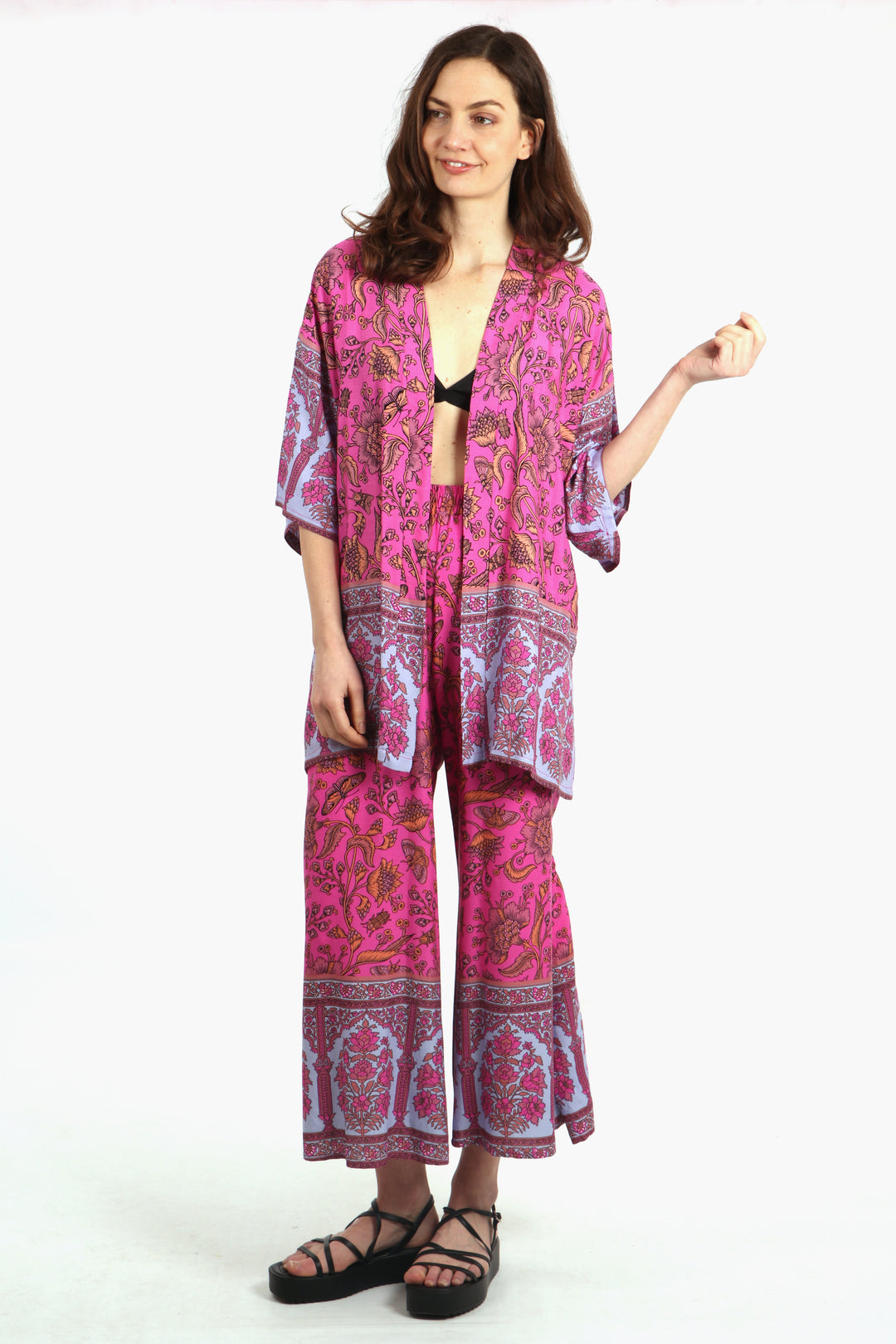 model wearing a hot pink ornate floral and butterfly pattern short kimono with matching palazzo pants