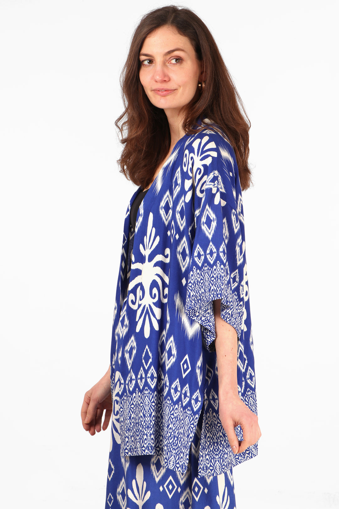 model wearing a blue and white ikat pattern short kimono top with 3/4 sleeves and an open front