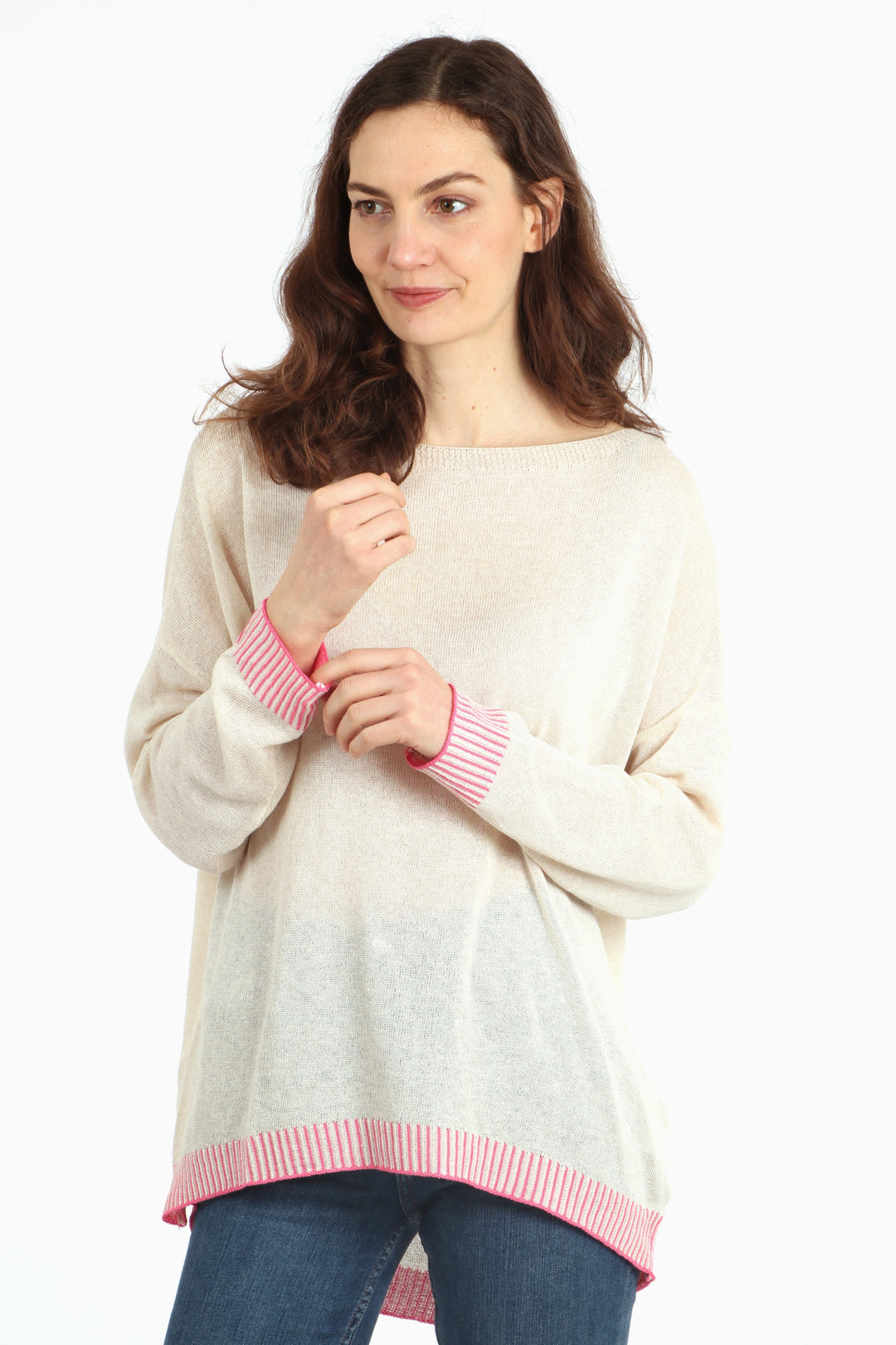 model wearing a long sleeved cotton jumper in cream with a contrasting pink stitched hem and cuff