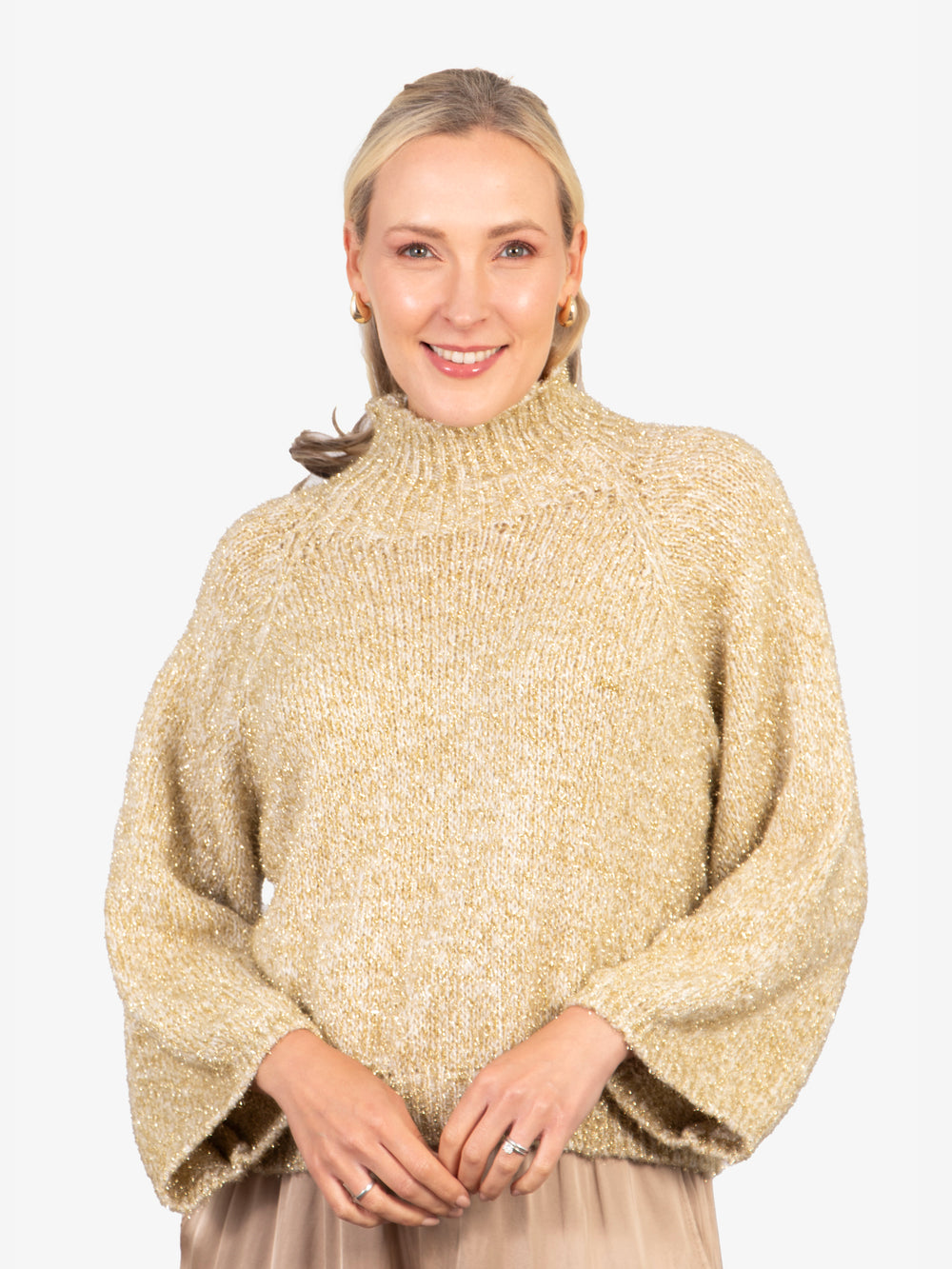 model wearing a gold sparkly knitted jumper, with a knitted high neck and an all over sparkly gold tinsel effect.