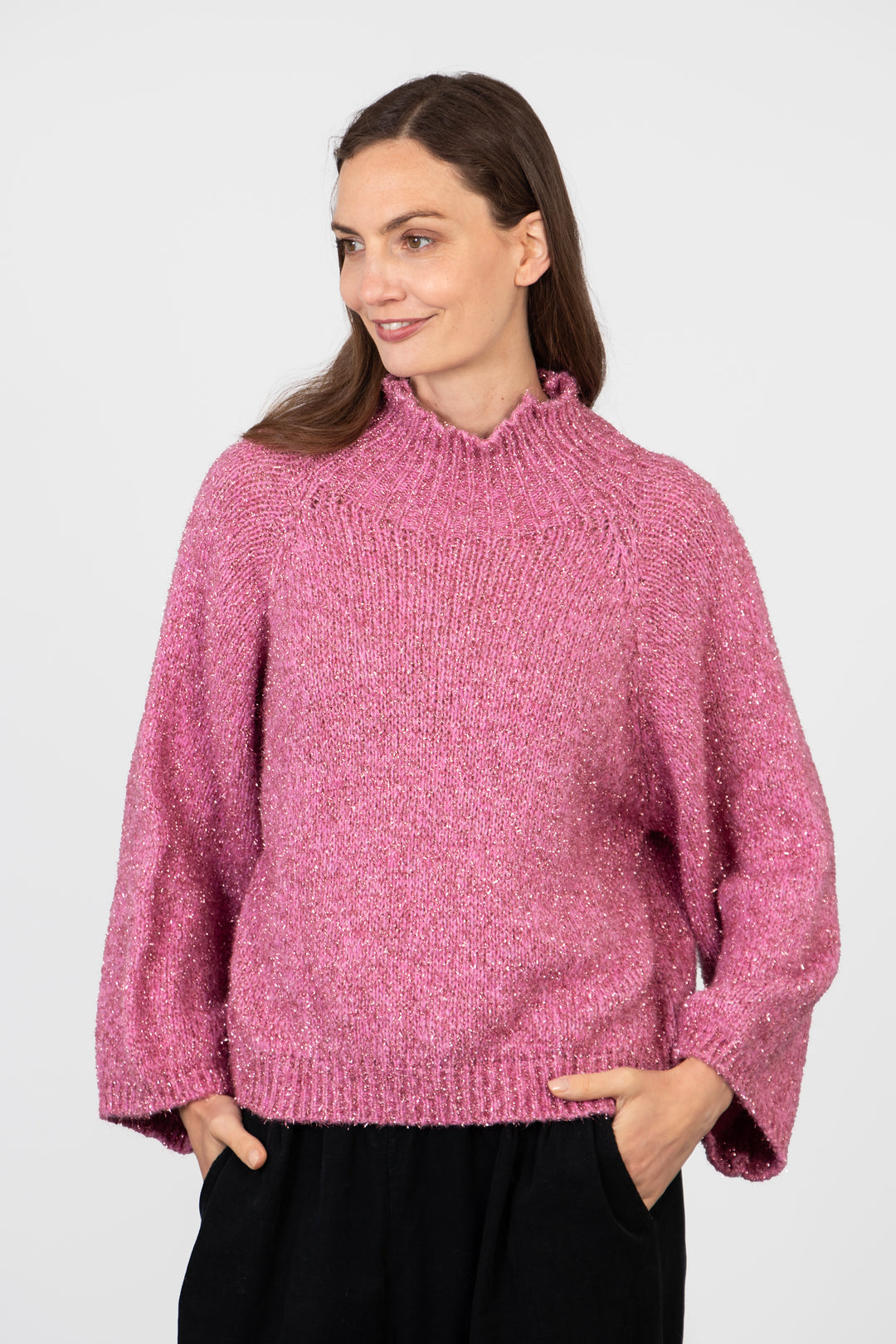 model wearing a sparkly pink jumper, showing the relaxed fitting design of the piece