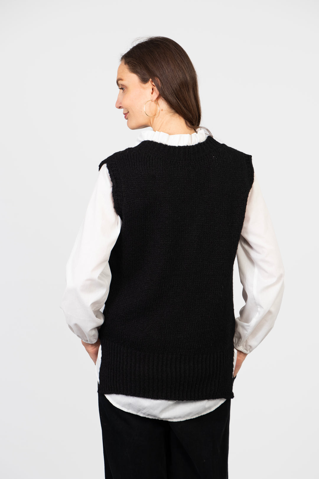 model showing the back of the black vest top, it is plain and has a round neck at the back