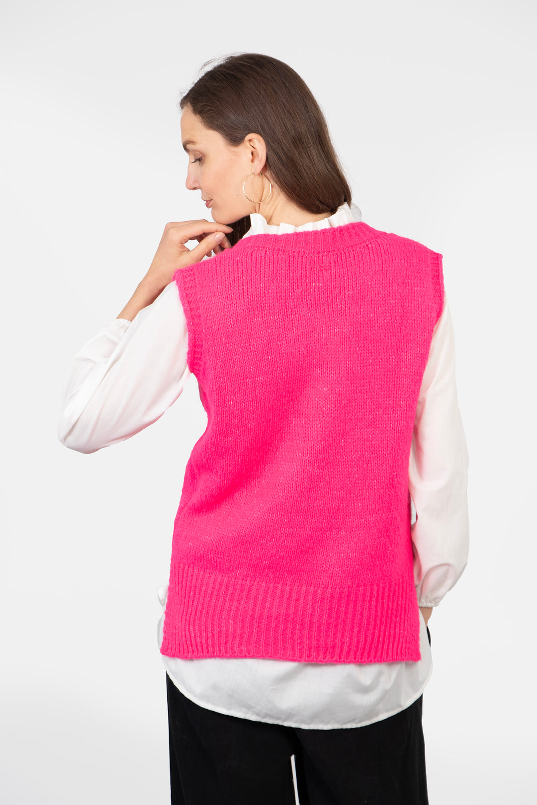 model showing the back of the vest, it is plain pink and has a ribbed trim