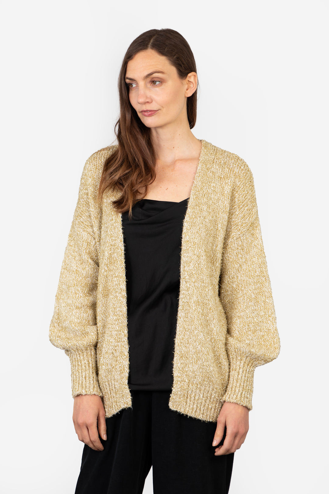 model wearing an open front gold sparkly cardigan