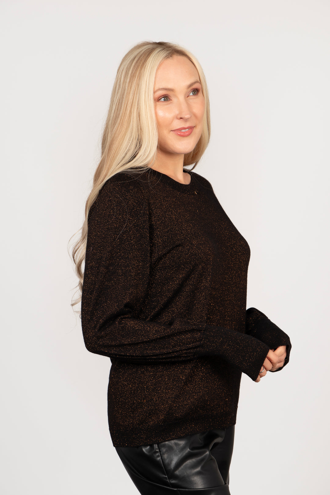 model wearing a bronze sparkly balloon sleeve knitted jumper. the jumper has a round neck and an all over sparkle.