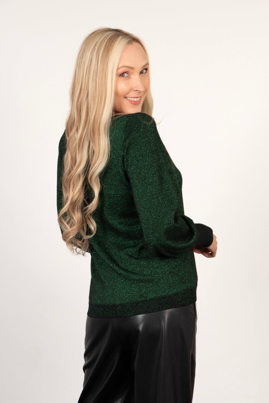 model showing the back of the green glitter jumper, showing the all over sparkle. the jumper is hip length