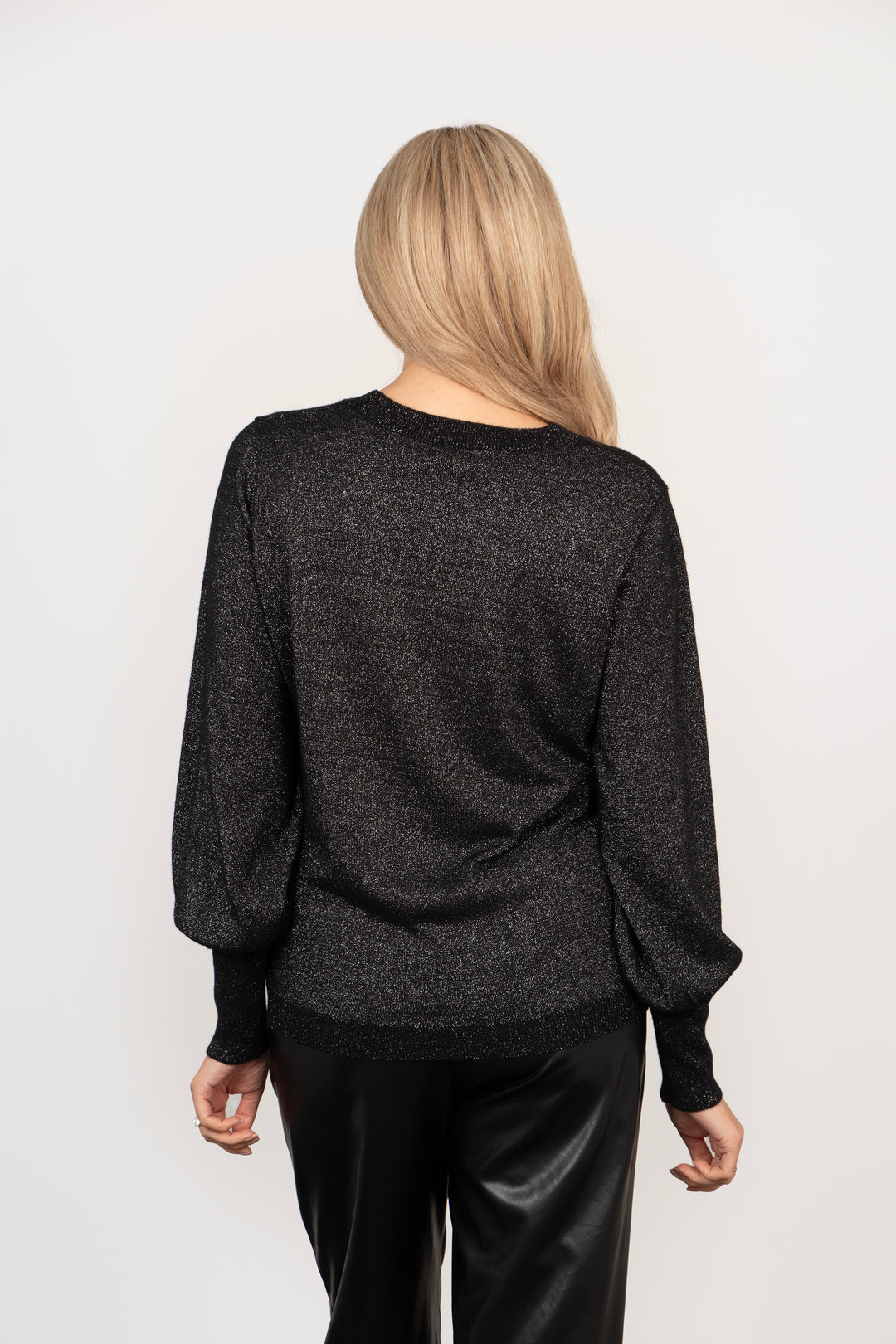 model showing the back of the knitted jumper, it has an all over silver sparkle and balloon sleeves