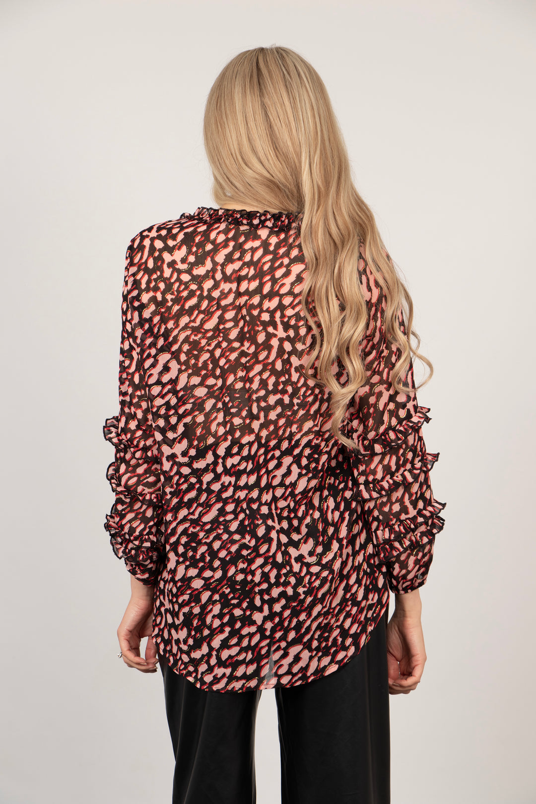 model showing the back of the blouse, the hem is longer at the back than the front