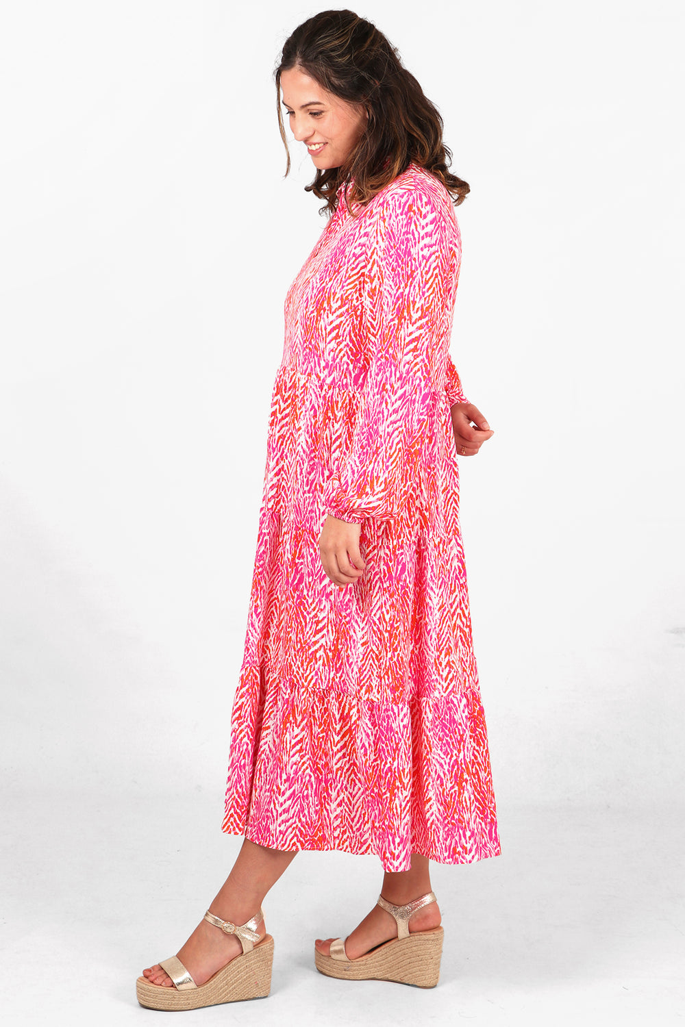 pink chevron print midi tiered dress with long sleeves and a loose fitting silhouette