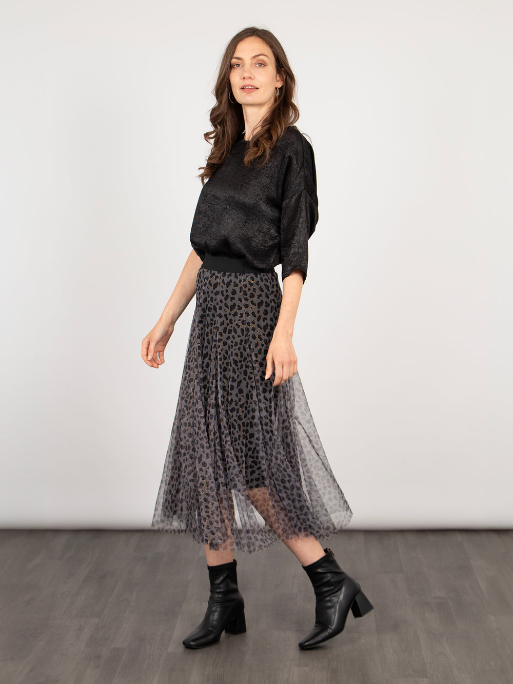 model wearing a grey tulle leopard print midi skirt, the skirt has an elasticated waist band