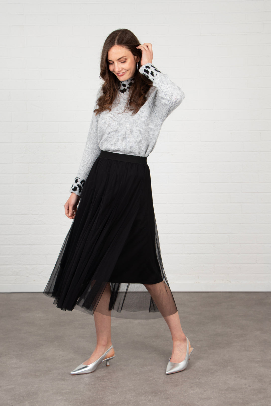 model wearing a black tulle swing skirt, showing that it has movement