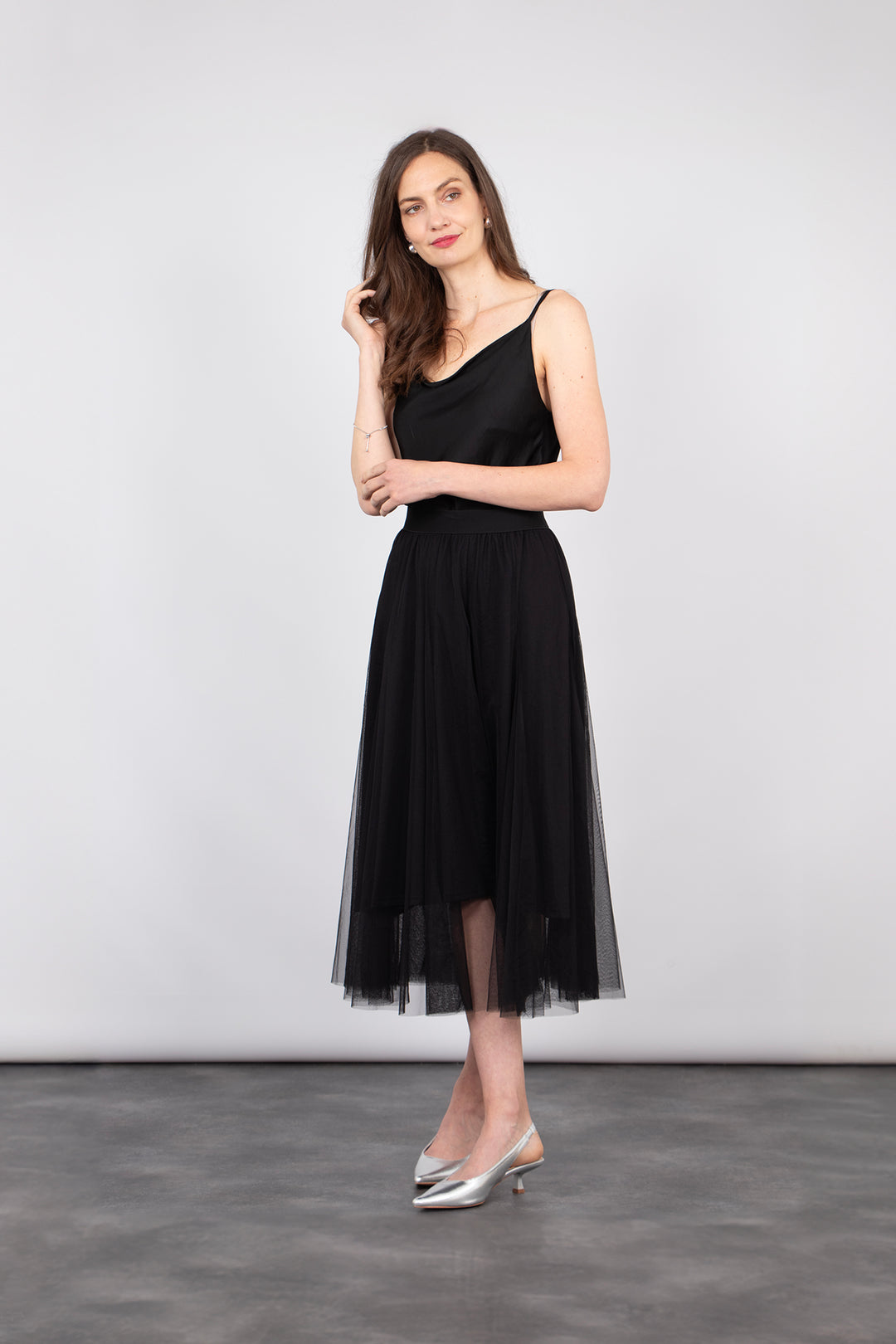 model wearing a black midi length ruffled tulle skirt