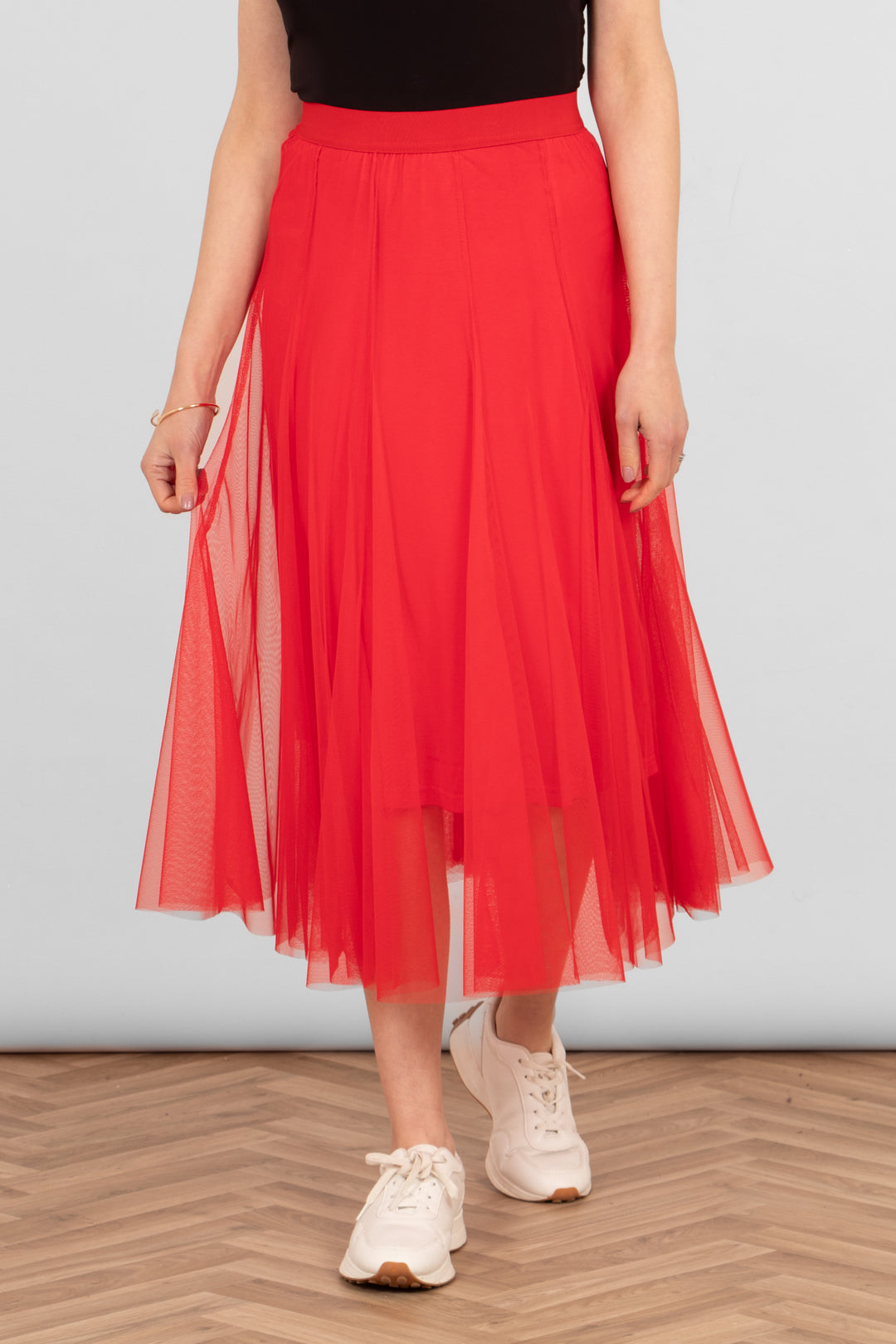 model wearing a plain red layered tulle midi skirt with a matching red underskirt and elasticated waistband