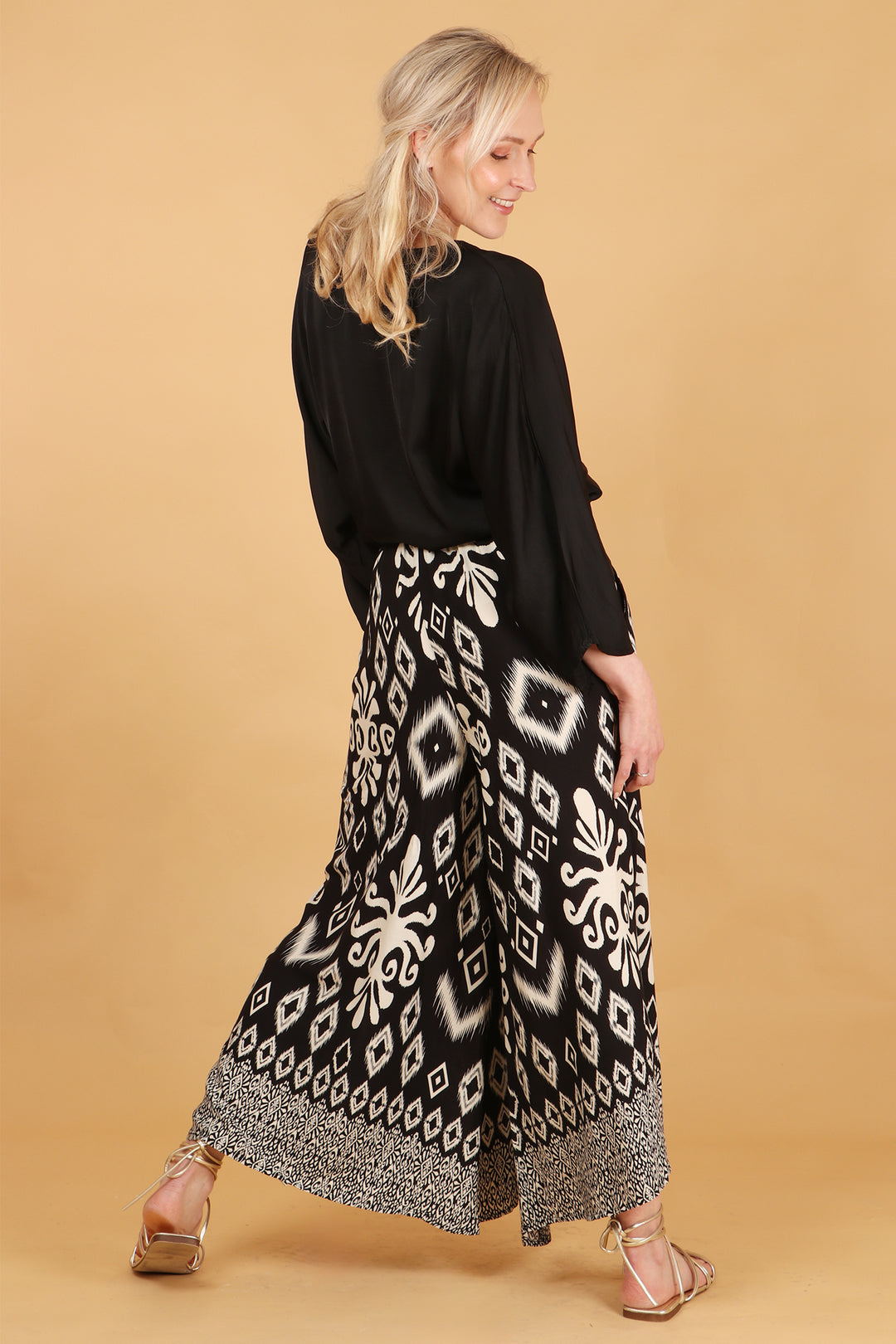 model showing the back of the palazzo pants showing an all over ikat pattern 