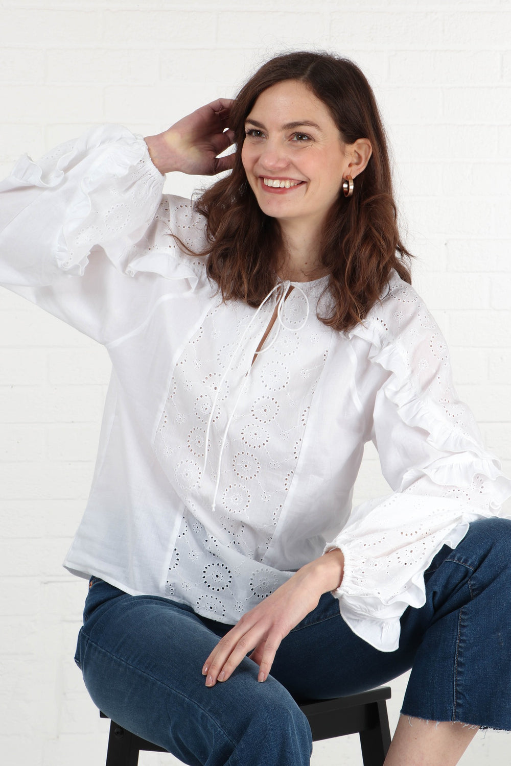 model wearing a long sleeve cotton blouse in white with broderie anglais details