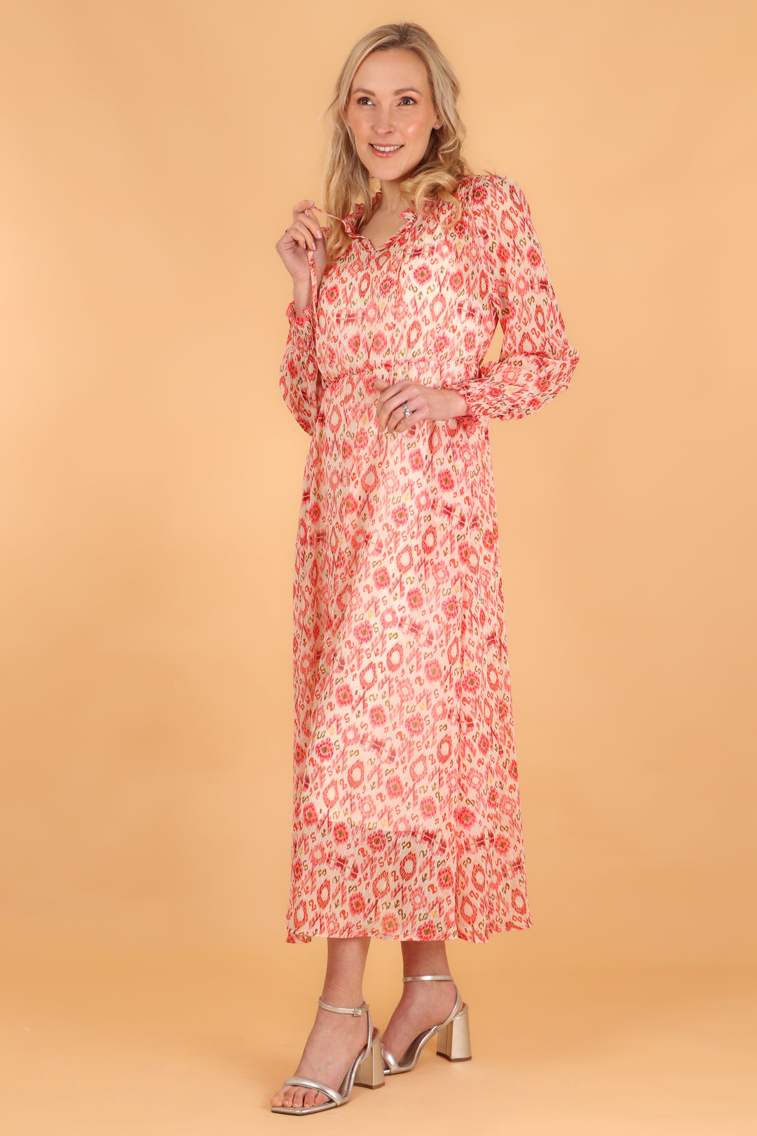 midi length coral ikat pattern long sleeve dress with shirring at the shoulders and a tie neck